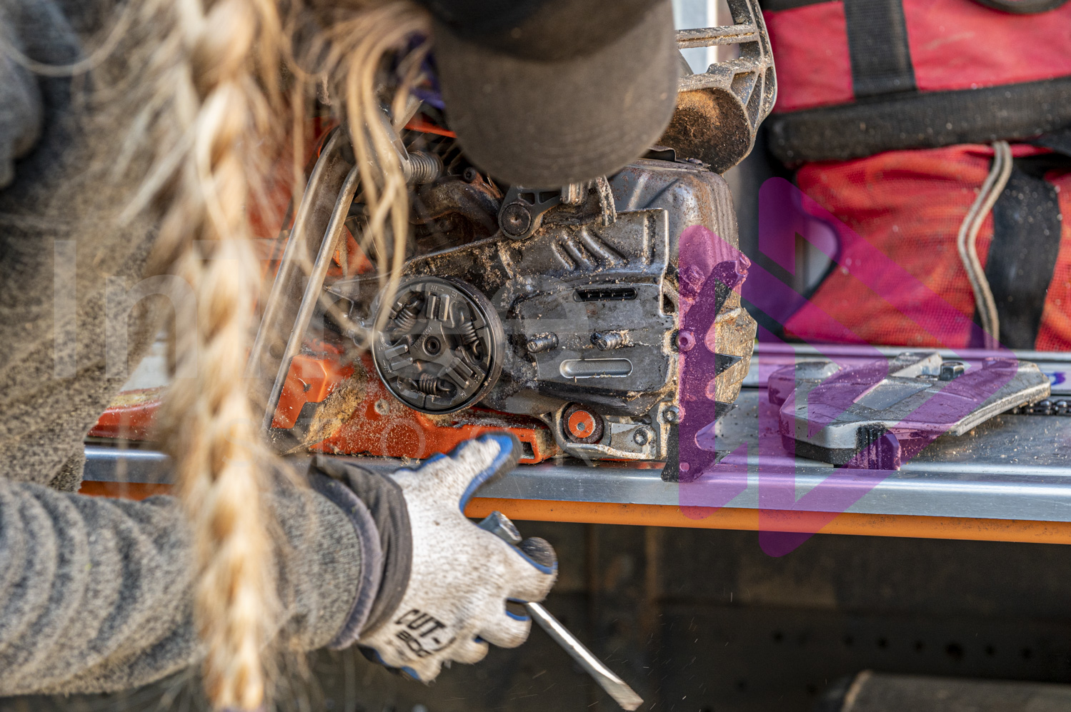 Woman cleaning and maintaining chainsaw