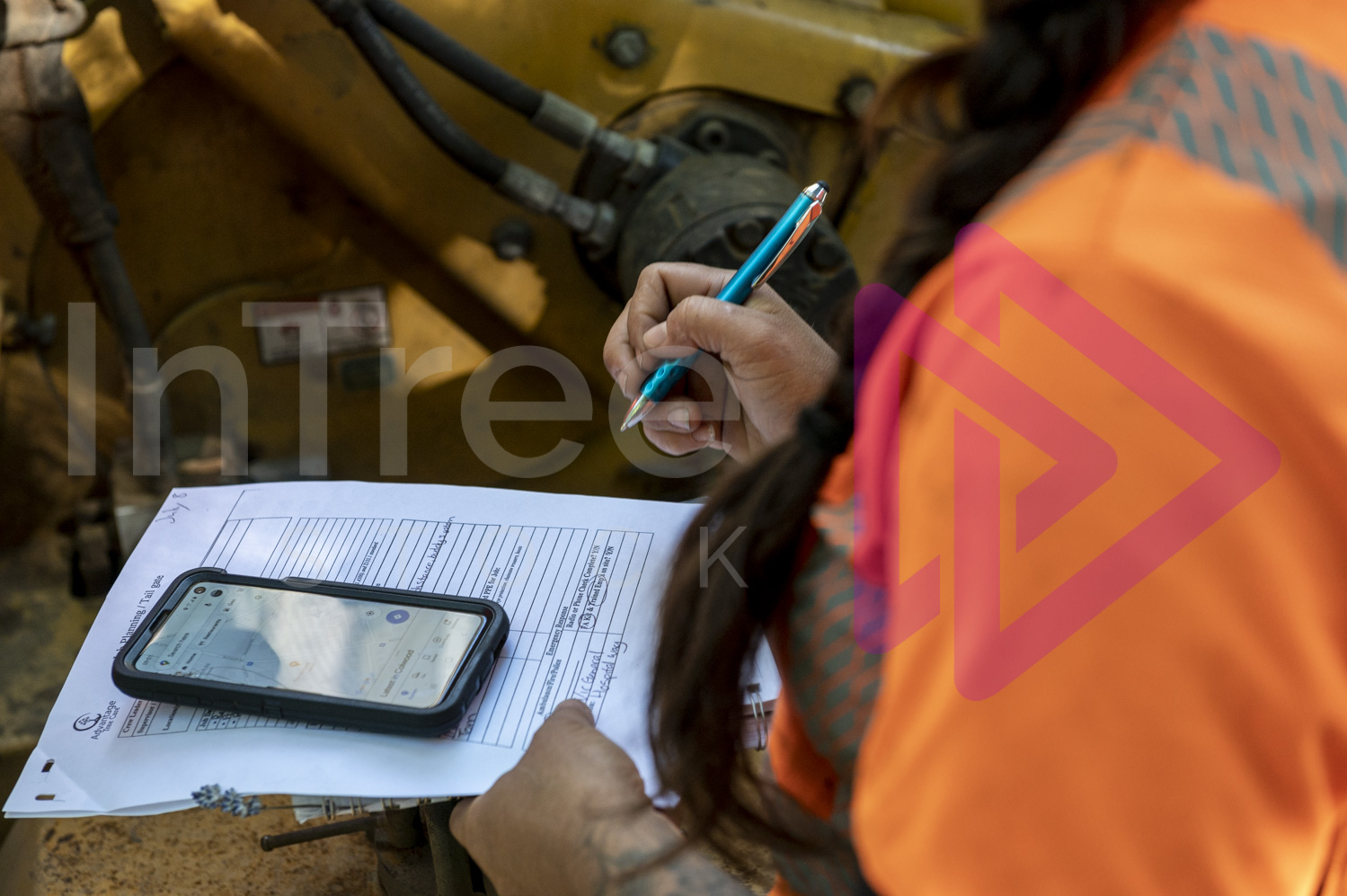 Female holding pen filling out form with smart phone