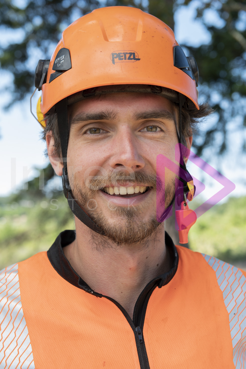 Headshot of man with a smile, wearing hi-vis top and orange helmet