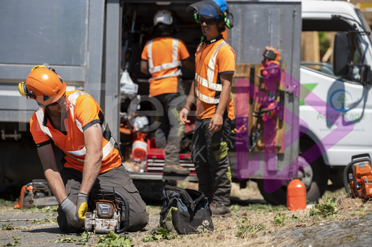 Male arborist tightening chainsaw chain