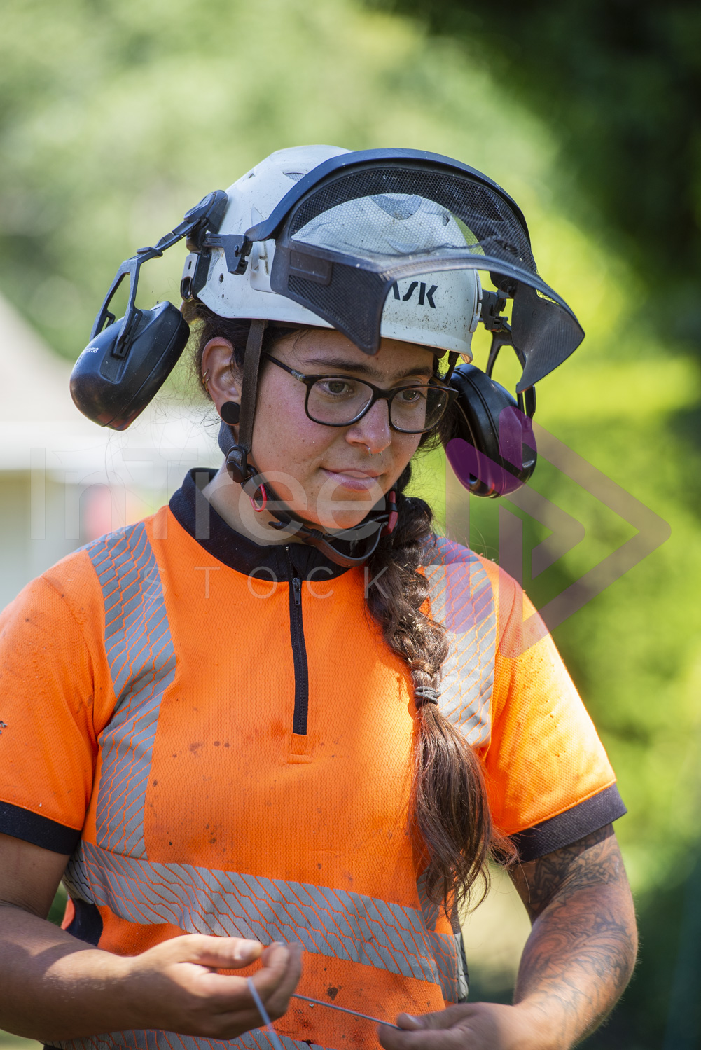 Female arborist in the zone with throw line in hand