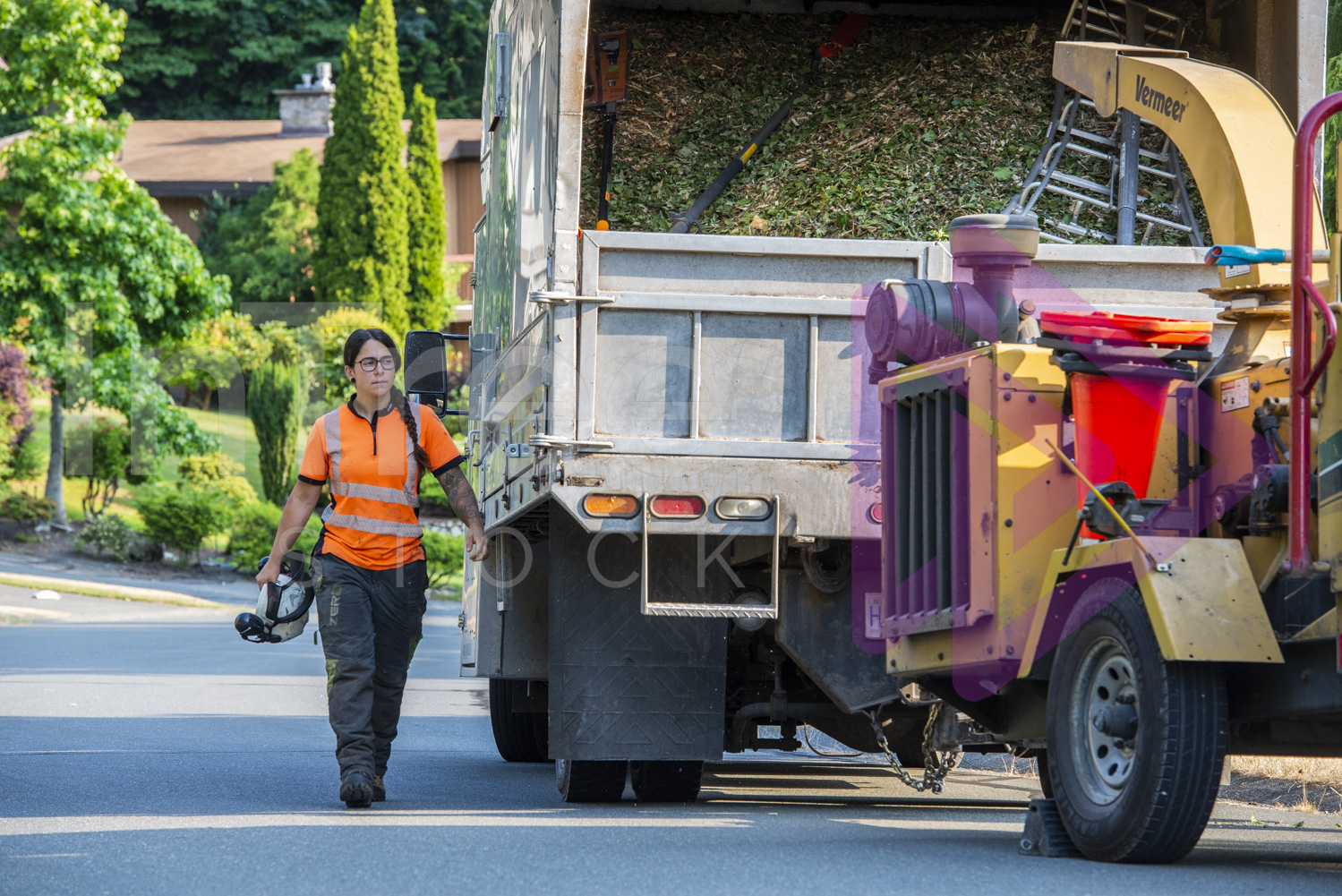 Female arborist walking alongside chip truck