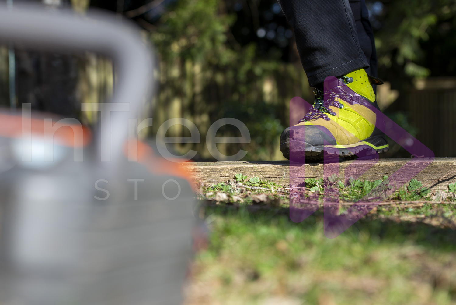 Green chainsaw protective boots in sunlight