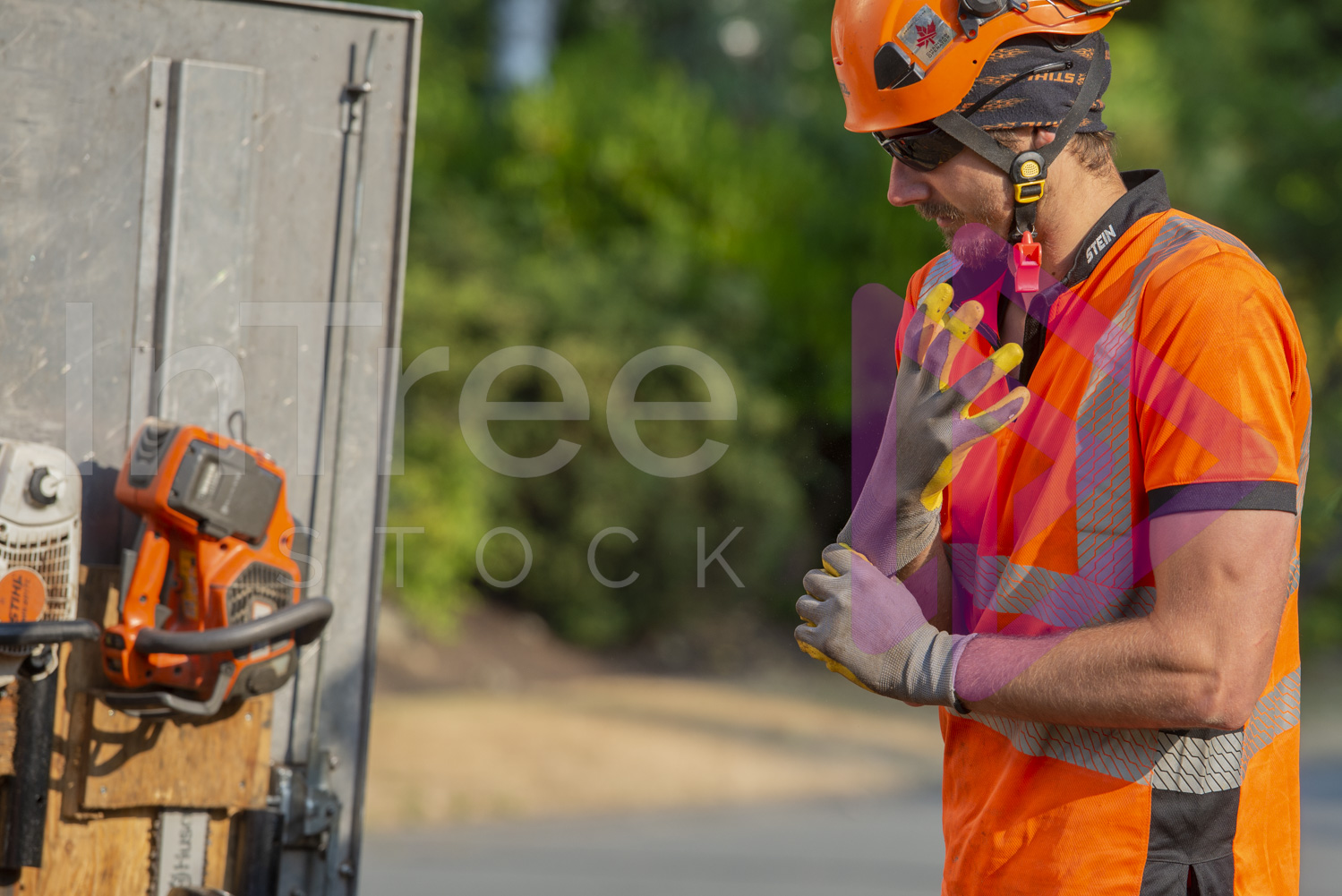Man wearing orange hi-vis putting gloves on
