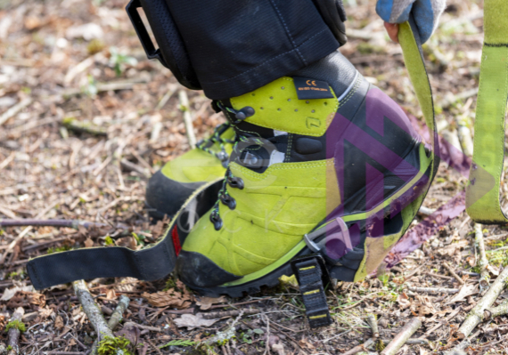 Close up of green chainsaw boots and spur straps Close up of green chainsaw boots and spur straps