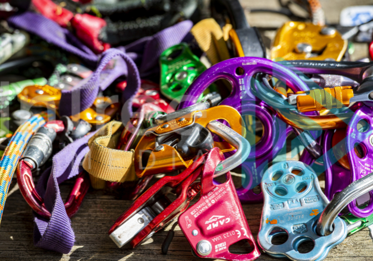 Colourful pile of climbing hardware, ascenders, pulleys carabiners