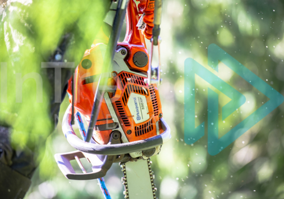 Chainsaw body with blurred background and sawdust particles