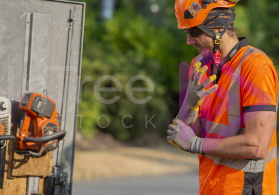 Man wearing orange hi-vis putting gloves on Man wearing orange hi-vis putting gloves on