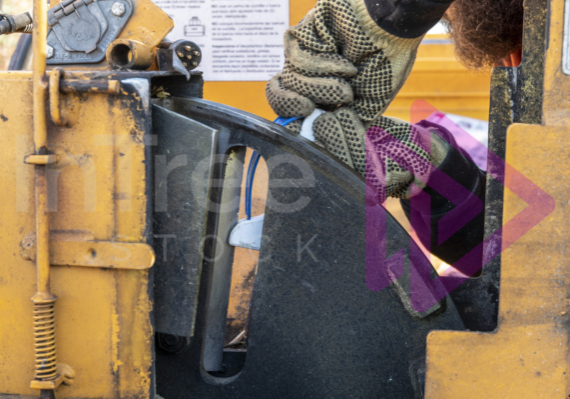 Gloved hands using a knife sharpener to sharpen chipper blades