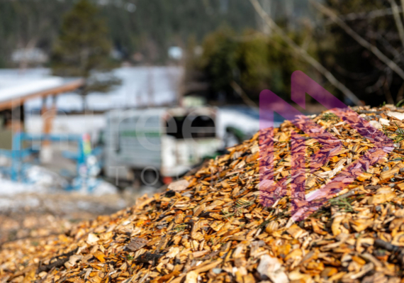 Woodchip pile with chiptruck in background