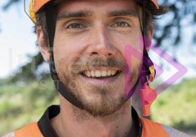 Headshot of man with a smile, wearing hi-vis top and orange helmet