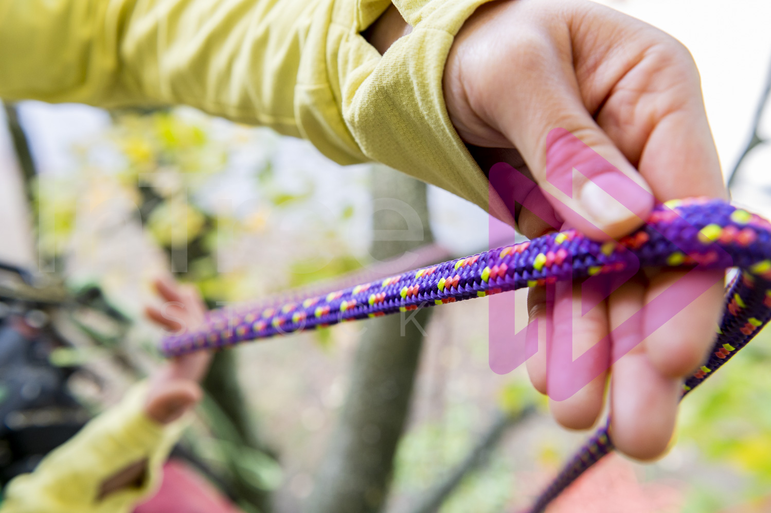 Female hands with pruple climbing rope